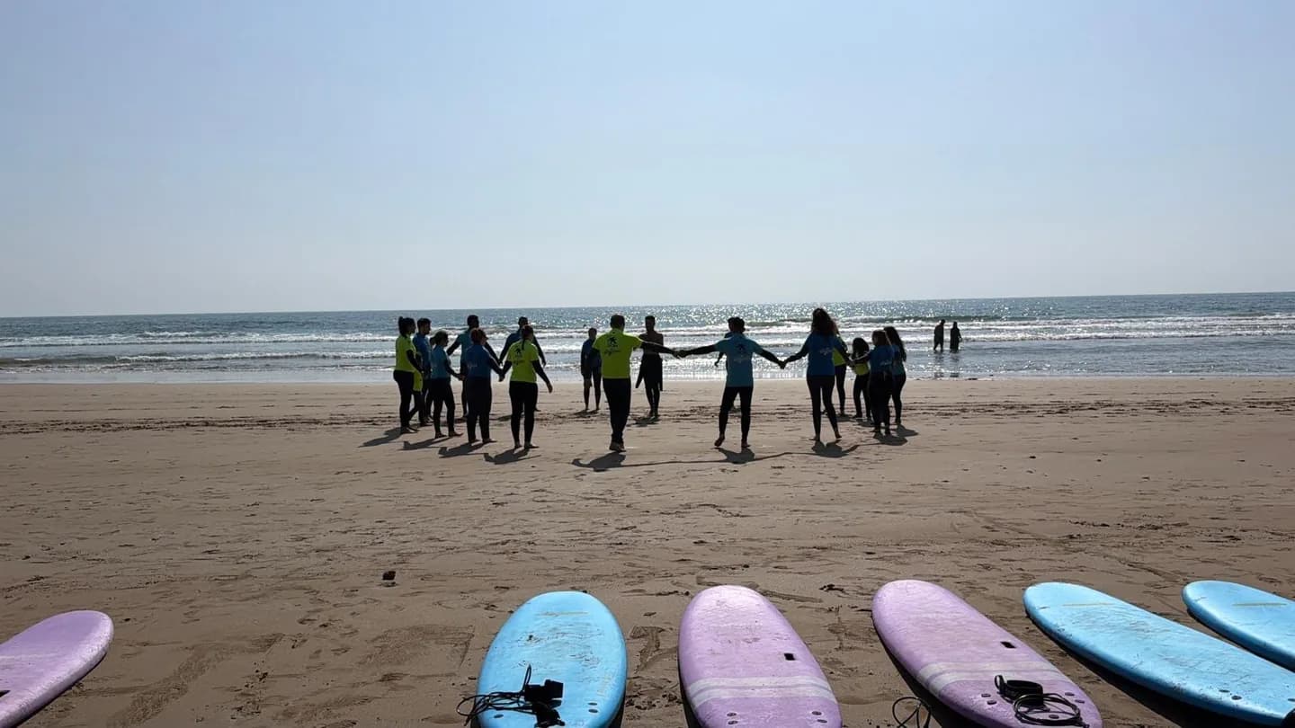 L'équipe en ligne sur le sable, face à l'océan